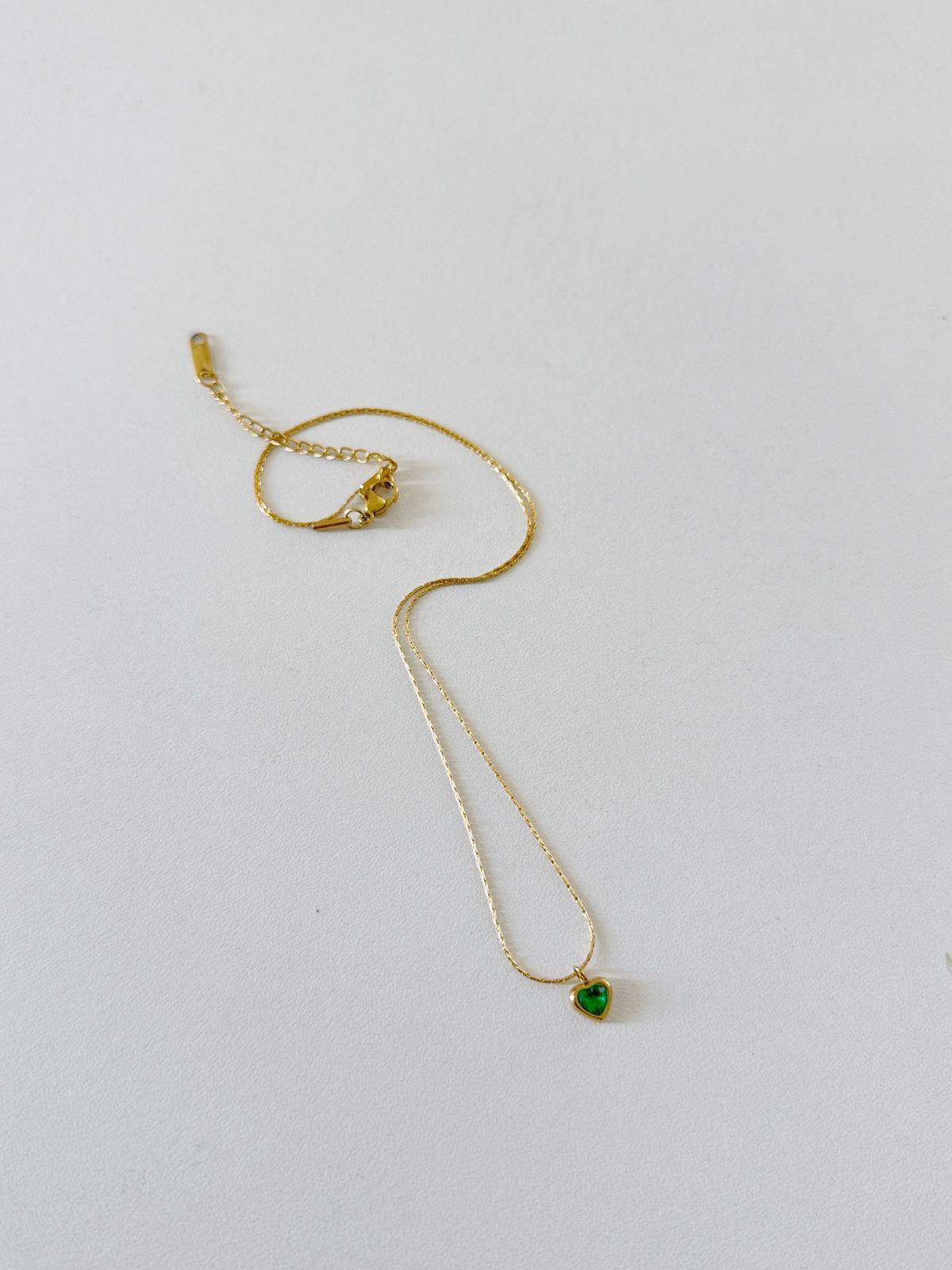 Collar dorado con corazon verde